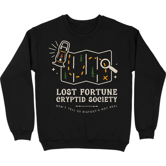 Black crewneck sweatshirt that has a map and lantern artwork. The words say "Lost Fortune Cryptid Society," and "don't tell us bigfoot's not real."