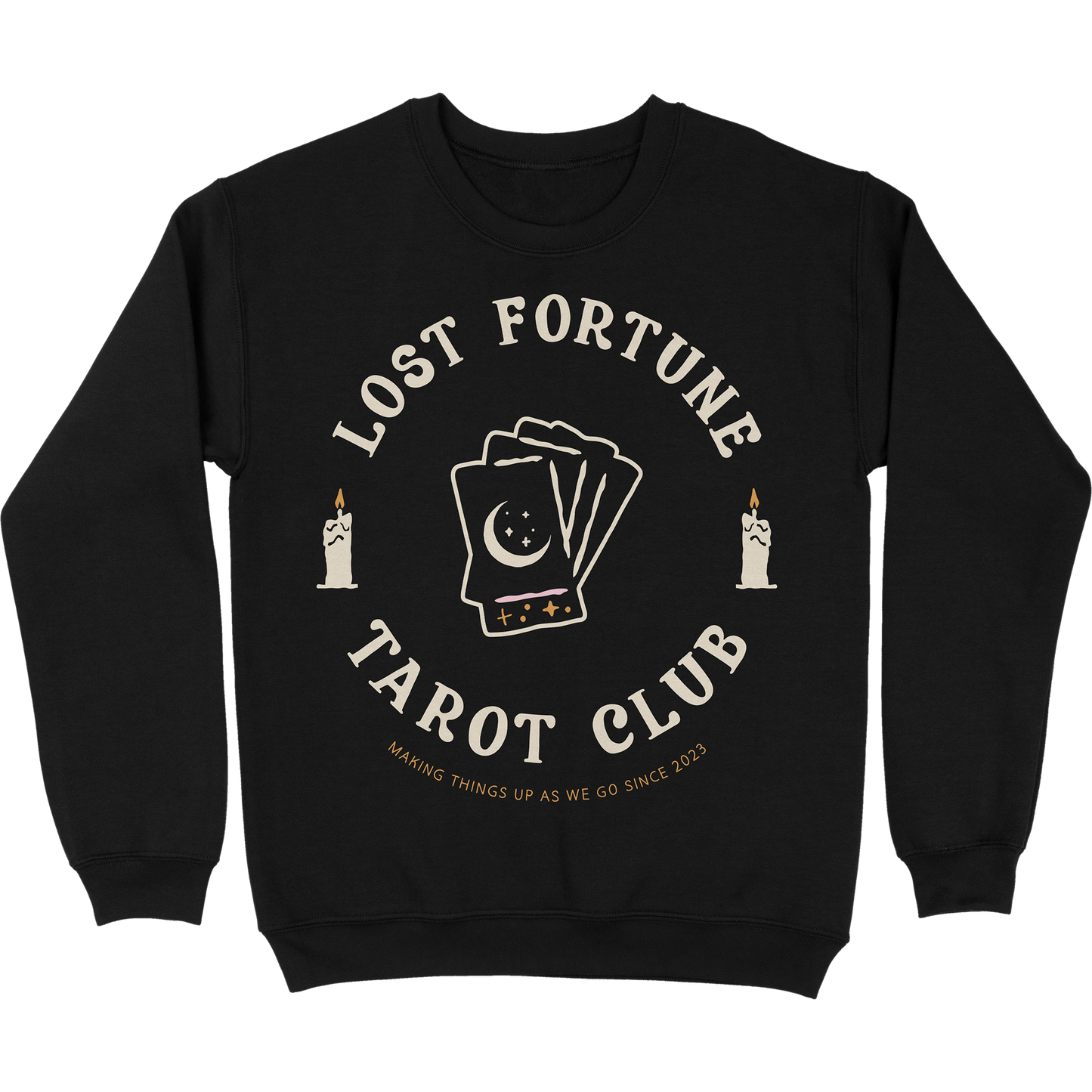 Black crewneck sweatshirt with artwork of candles and a stack of tarot cards with a moon and stars on the front. The text reads "Lost Fortune Tarot Club. Making things up as we go since 2023." 