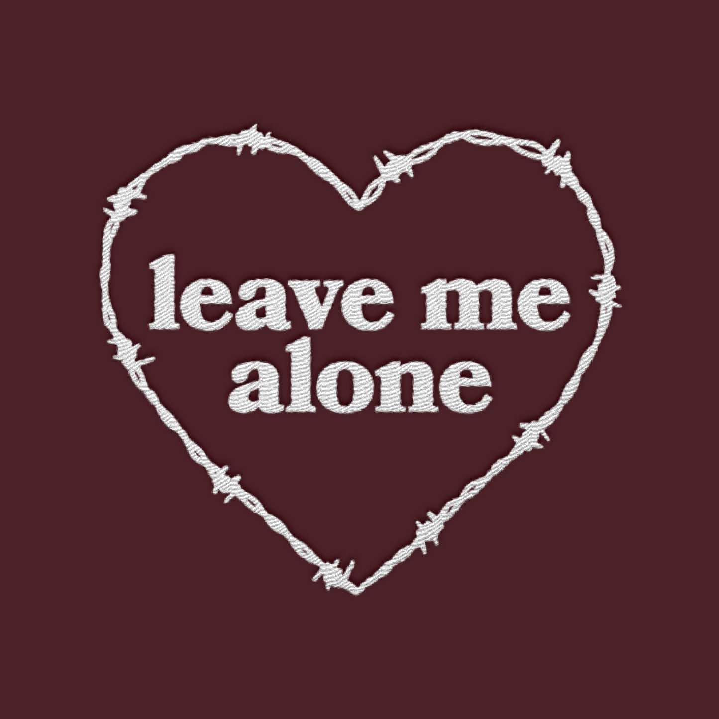 Artwork of a barbed wire heart surrounding the words "leave me alone"